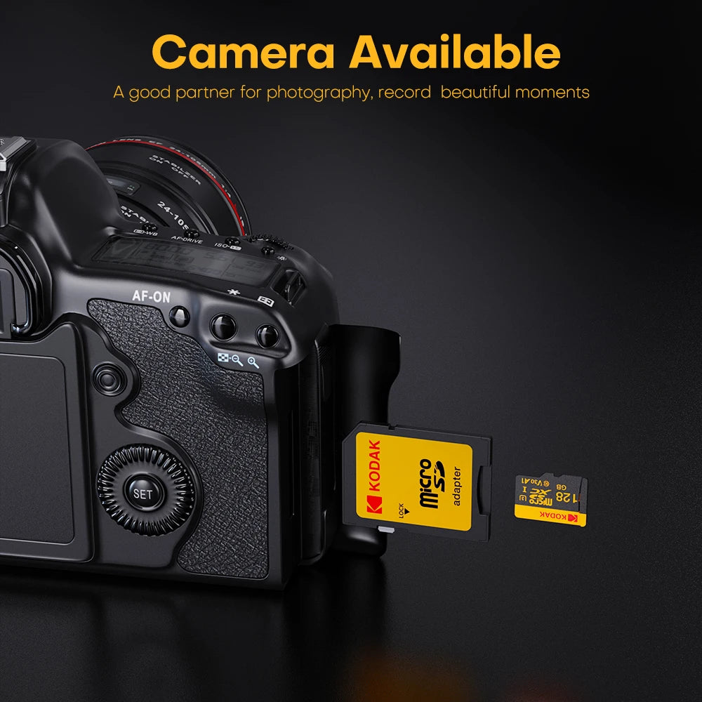 A black camera body with a lens and a yellow Kodak SD memory card adapter displayed on a dark surface.
