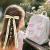 Cheveux d'une fille tressés avec un ruban satiné portant des lettres de Noël, à côté d'un sac à dos rose.
