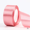 A roll of pink satin ribbon for gift wrapping and DIY crafts.