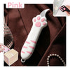 A pink cat paw shaped utility knife is shown against a brown fabric background with a small box.