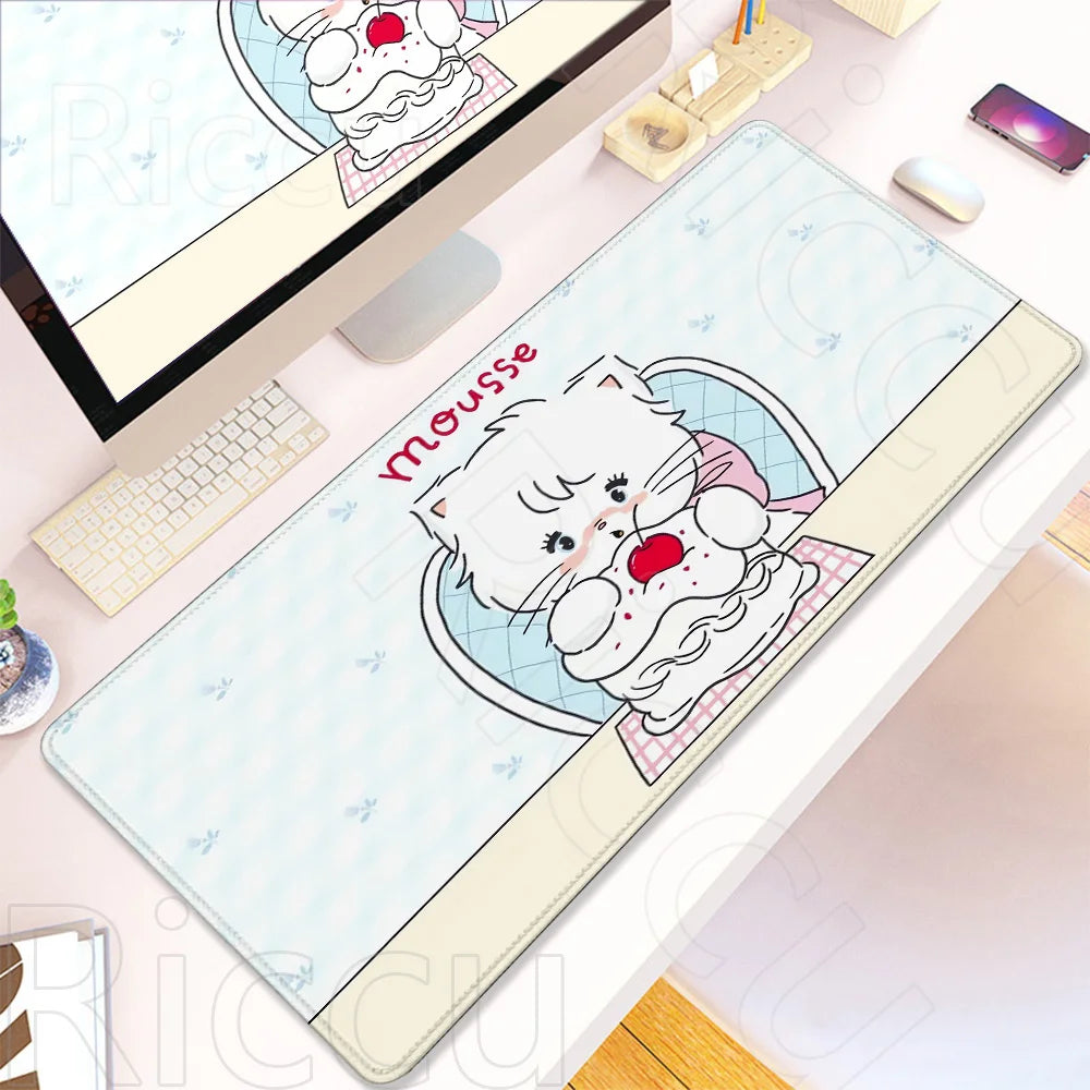 A white cat cartoon design on a light blue desk mat placed next to a laptop and a mouse.