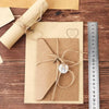 A set of vintage European style letter and invitation envelopes tied with twine on a wooden surface next to a ruler.