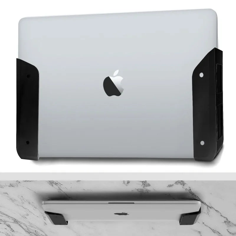 A silver laptop is shown mounted on an under-desk clamp with black silicone padding.