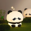 A cute panda silicone night light with touch control and USB rechargeable, glowing softly on green moss.