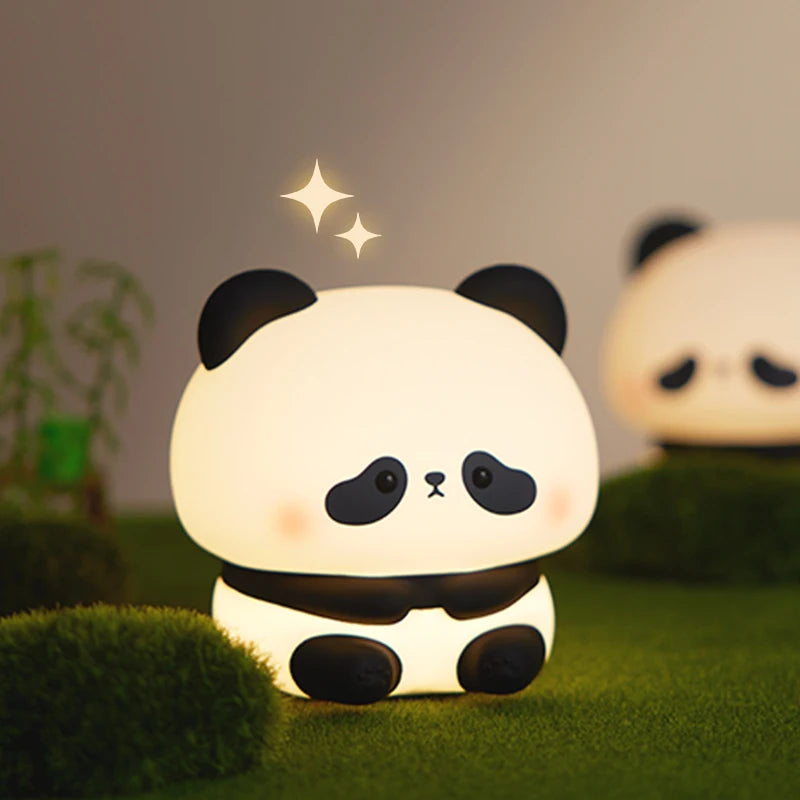 A cute panda silicone night light with touch control and USB rechargeable, glowing softly on green moss.