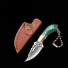 A compact fixed blade knife with a green handle and silver blade is shown next to its leather sheath.