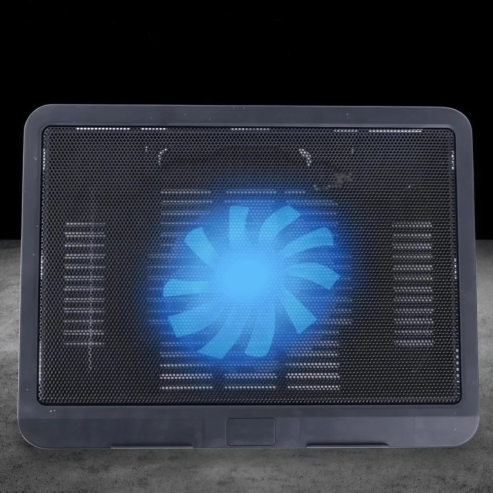 A laptop cooling pad with a blue glowing fan visible through the grille on a dark surface.
