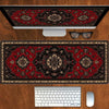 A vintage Persian rug gaming mouse pad with a non-slip rubber base is shown on a wooden desk next to a computer monitor and k