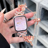 A hand holds a pink smartwatch with a rose gold butterfly watch strap and bow detail.