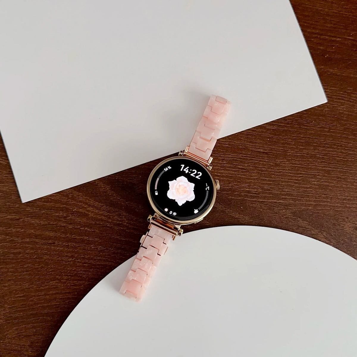 A pink resin beaded watch with a black face and rose motif is displayed on a white background.