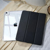A black universal protective case for an Apple iPad lying on a light yellow fabric.