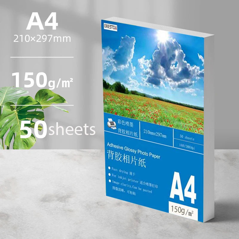 A package of A4 glossy photo paper sheets with a vibrant blue sky and clouds visible.