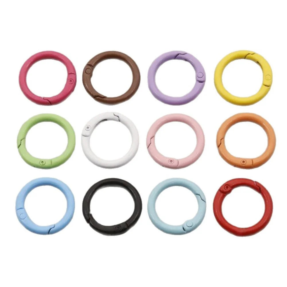 A set of colorful spring clasps keychains in various colors including pink, yellow, purple, white, and black.