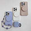 A set of ripple grip magnetic phone stands in light purple and beige silicone finishes with attached lanyards.
