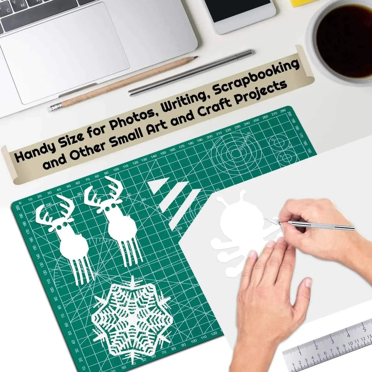 A hand is using a pen on a green cutting mat with a snowflake design for crafting and art projects.
