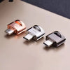 A close-up of two Type-C to Micro-SD card readers, one rose gold and one silver, resting on a neutral surface.