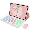 A pink laptop case with a backlit keyboard and a nature-themed design on the screen, next to a pink mouse.
