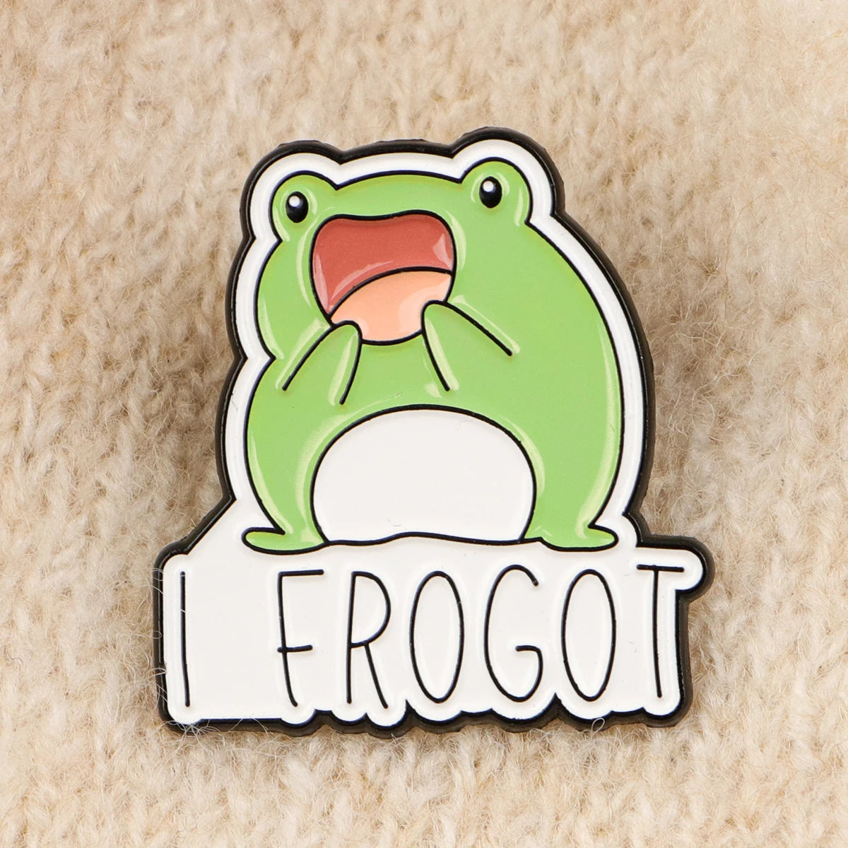 An enamel pin featuring a cartoon frog with an open mouth and the text FROGOT.