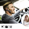 A man in a suit is using wireless Bluetooth earphones with a microphone while looking out of a car window.