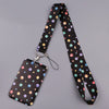 A black heart-shaped minimalist lanyard with colorful polka dots attached to a black card.