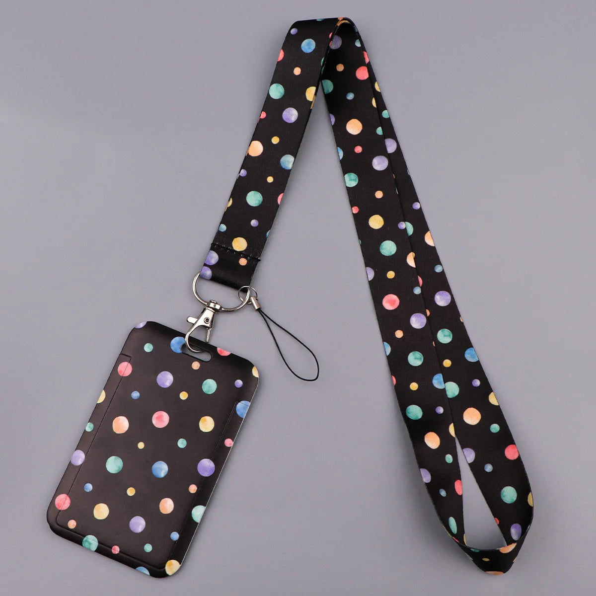 A black heart-shaped minimalist lanyard with colorful polka dots attached to a black card.