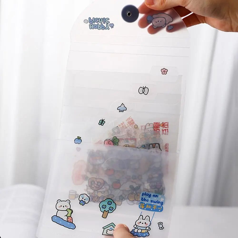 A hand holds a transparent storage book filled with various stickers and documents.
