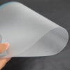 A clear, anti-glare matte screen protector rolled into a cylinder is being held by a hand.