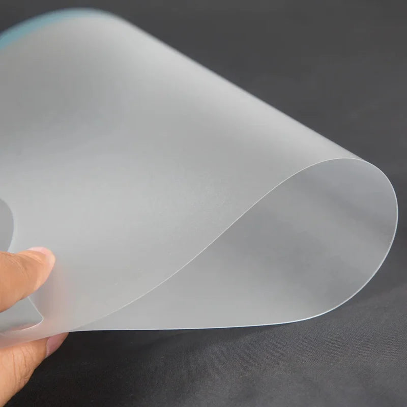 A clear, anti-glare matte screen protector rolled into a cylinder is being held by a hand.