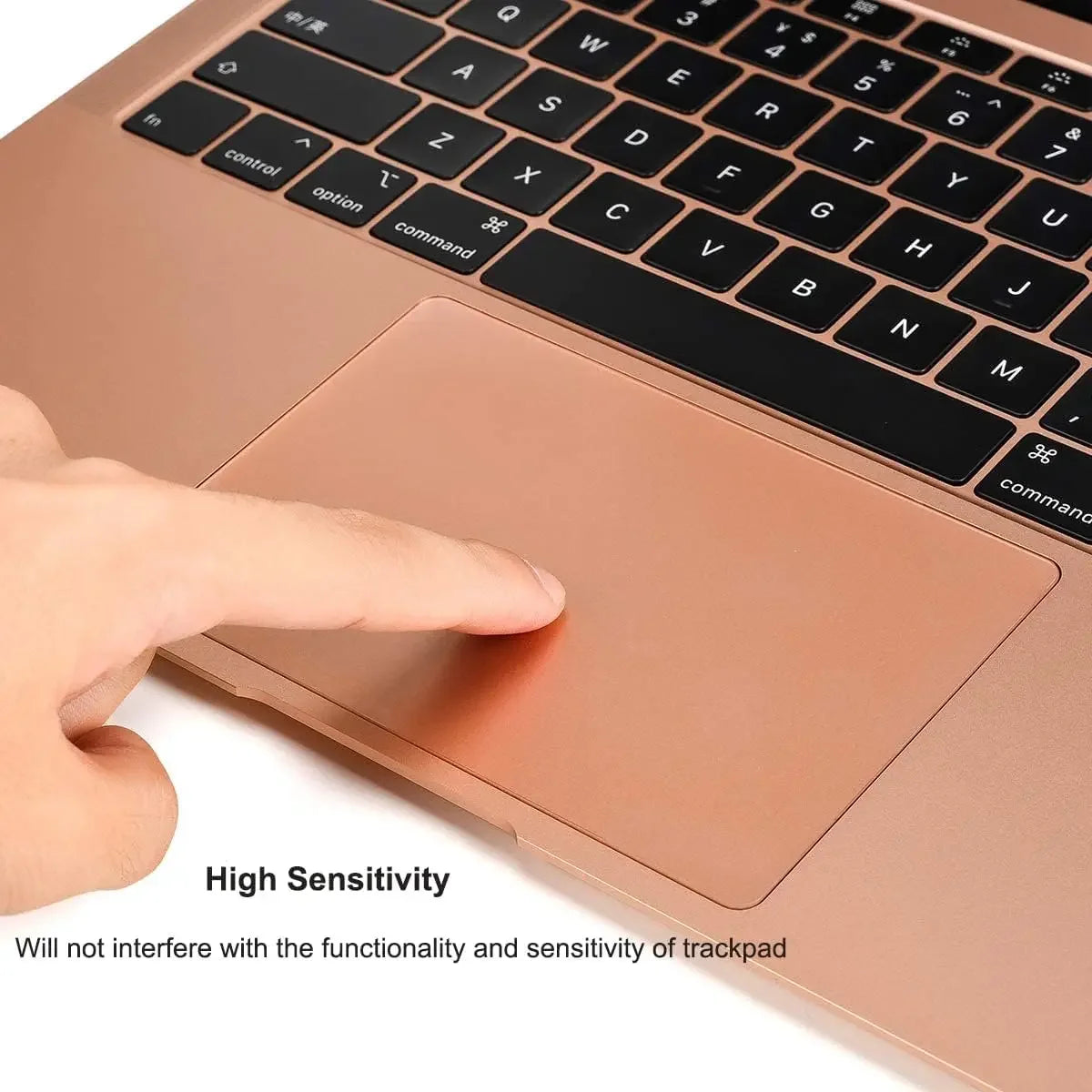 A hand is touching the smooth, rose gold trackpad area of a laptop, demonstrating high sensitivity.