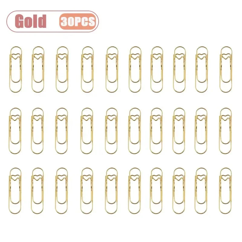 A set of thirty gold metal pen clips for notebooks and journals.