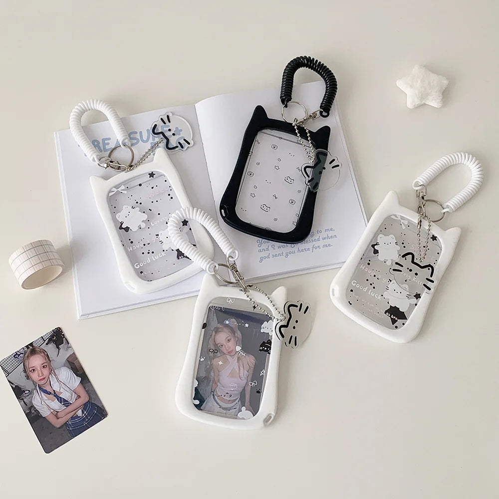 Sammlung von Silikon-Katzen-Anhänger-Leser-Halterungen in Weiß und Schwarz mit verschiedenen Designs und Aufhängungen.