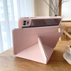 A pink magnetic protective case for an iPad, shown resting on a wooden table next to a smartphone.