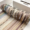 A collection of vintage colored washi tape rolls arranged in a line on a wooden surface.