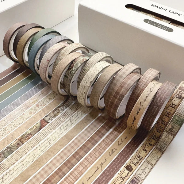 A collection of vintage colored washi tape rolls arranged in a line on a wooden surface.