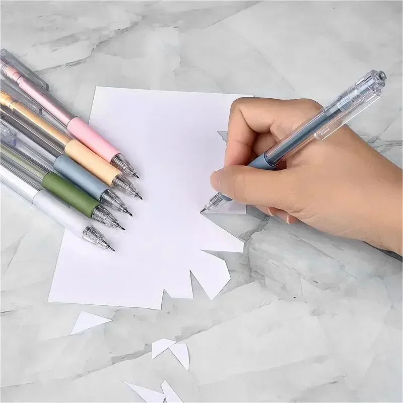 A hand is using a precision craft knife set with various colored blades to cut paper on a marble surface.