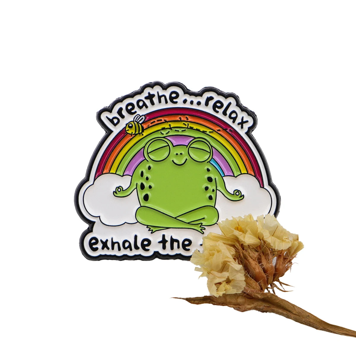 Enamel pin featuring a green frog sitting on a rainbow with text that reads breathe relax exhale the