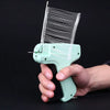 A hand holds a light green apparel tagging gun kit with a fine wire tag applicator.