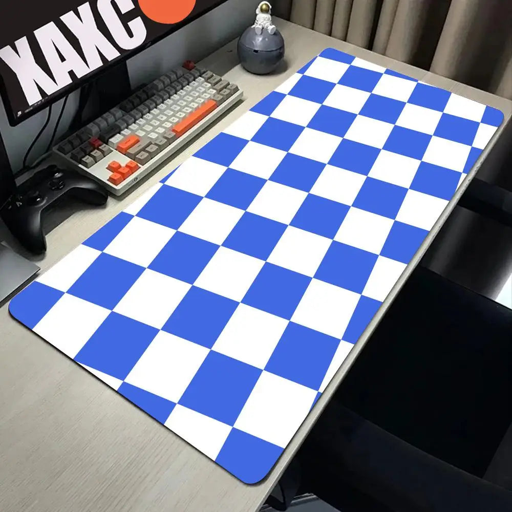 A blue and white checkered desk mat is displayed on a wooden desk next to a keyboard and a mouse.