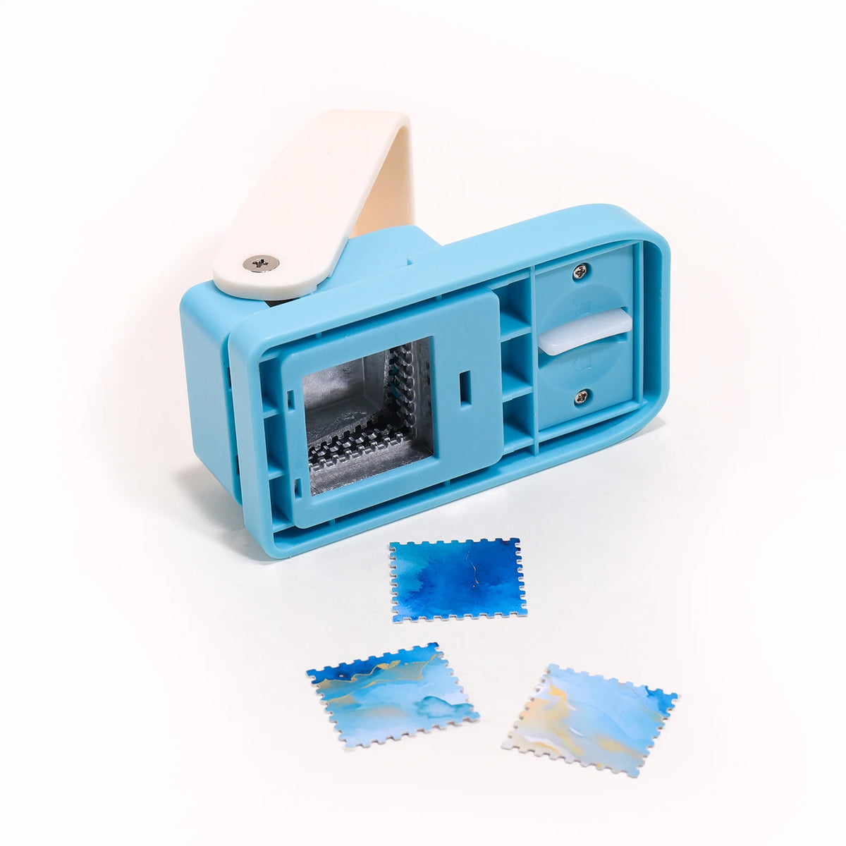 A light blue embossing punch machine with a white handle and several blue and yellow foil stamps.