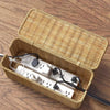 Handwoven rattan cable management box with lid containing white power strips and cables