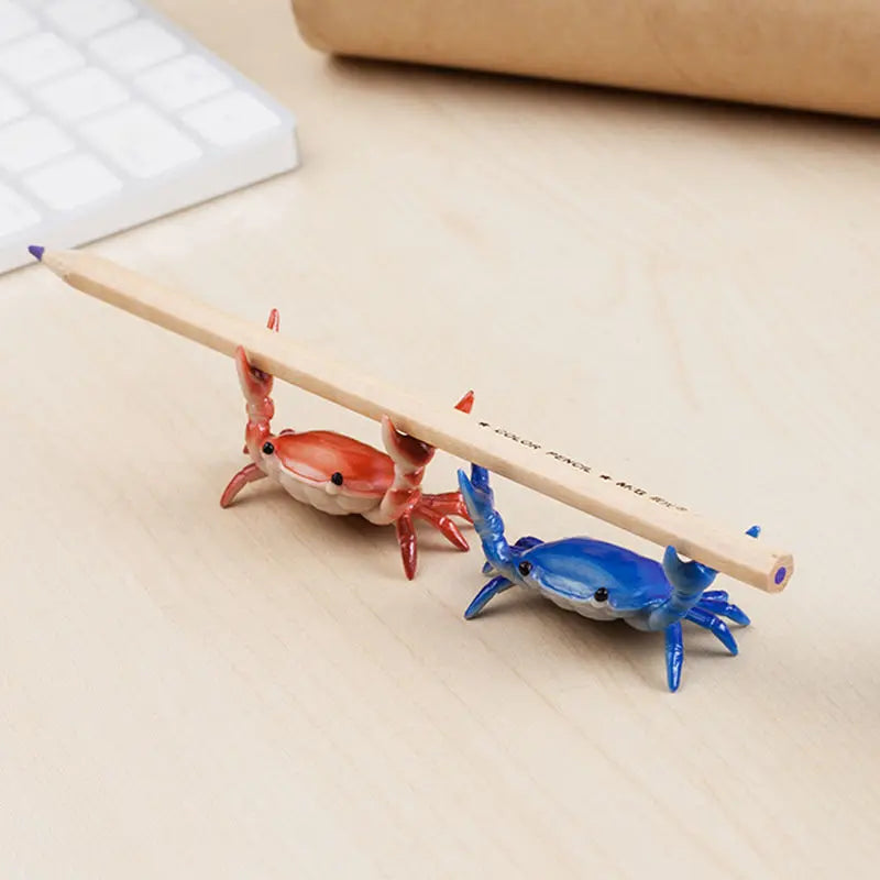 Un porte-stylo en bois en forme de crabe fantaisiste, avec des figurines peintes en rouge et bleu.