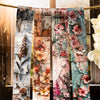 A collection of decorative washi tape featuring floral and botanical patterns tied together on twine.