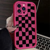 A pink silicone phone case with a black and pink checkered pattern is shown on a laptop.