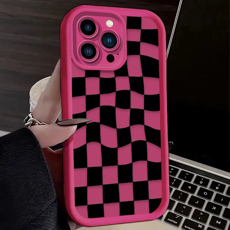 A pink silicone phone case with a black and pink checkered pattern is shown on a laptop.