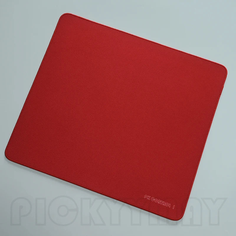 A red professional gaming mouse pad desk mat lying flat on a light surface.
