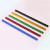 A set of aluminum triangular scale rulers in various colors, including black, yellow, green, red, and blue, laid out on a whi