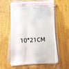 A stack of clear self-sealing plastic bags for jewelry, candy, and gifts is shown on a wooden surface.