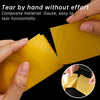 Hands tearing a yellow composite material like gauze horizontally to demonstrate easy tearing.