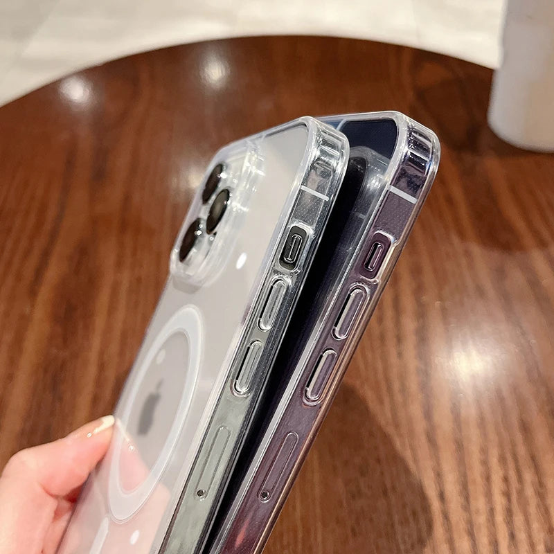 A hand holds a magnetic transparent phone case, showing different colored cases stacked together on a wooden surface.