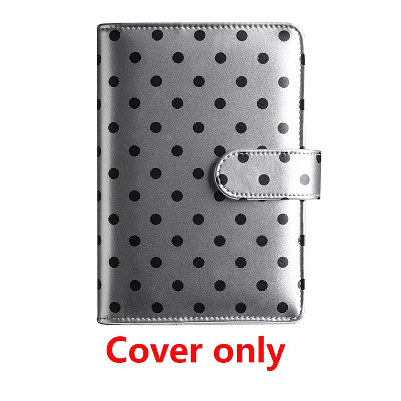 Silver faux leather binder cover with black polka dots and a snap closure.